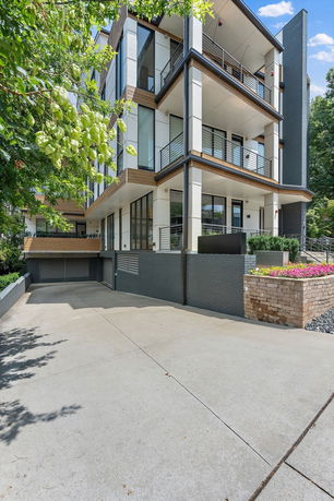 Front view of a modern multi-story building with balconies and large windows.