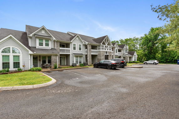 Front view of a two-story residential building with multiple units and a parking area.