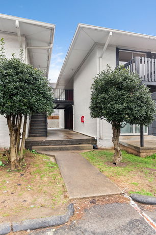 Front view of a two-story building with an external staircase.