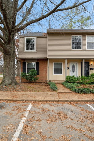 Front view of a two-story townhouse with brick and siding exterior.