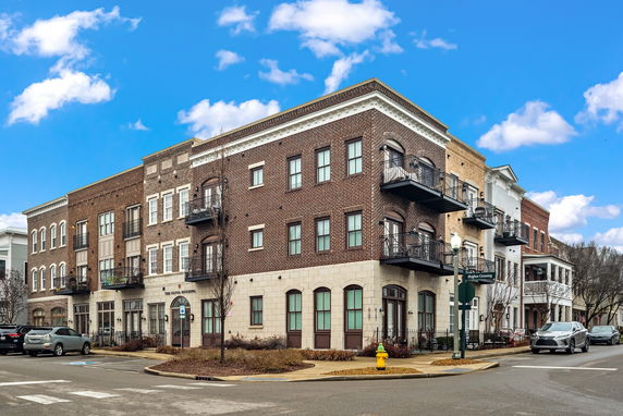 Front view of a multi-story brick building with balconies.