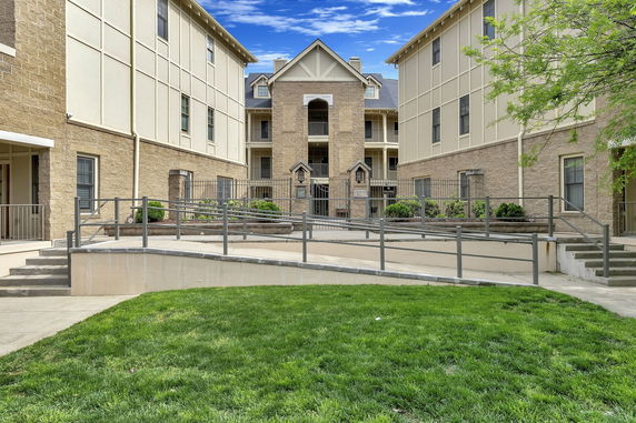 Front view of a multi-story building with beige and stone facade.