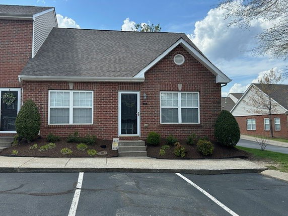 Front view of a single-story brick house with a gable roof.