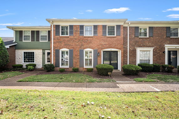 Front view of a two-story brick townhouse with adjacent units.
