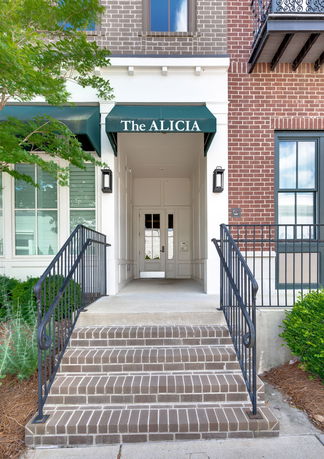Front view of a building entrance with brick steps and awning.