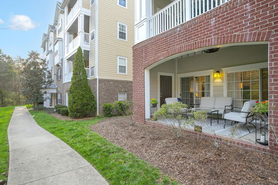 Front view of a multi-story building with a patio and seating area.