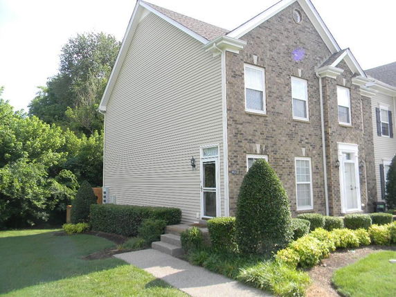 Front view of a two-story house with brick and siding exterior.