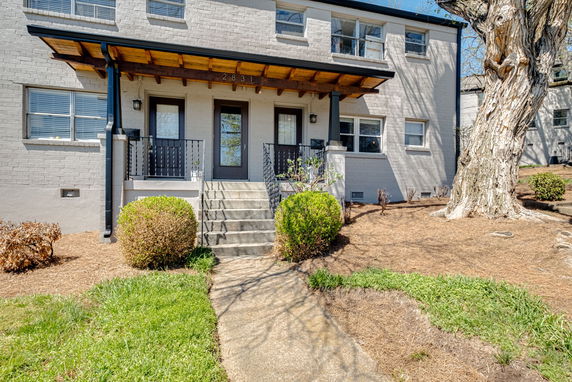 Front view of a two-story house with a covered porch and steps.