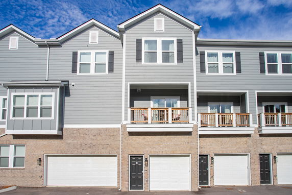 Front view of a multi-story townhouse with attached garages.