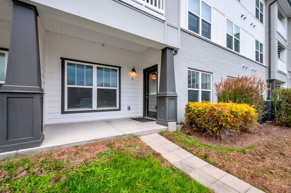 Front view of a multi-story residential building with a small porch area.
