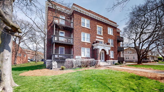 Front view of a multi-story brick building with balconies.