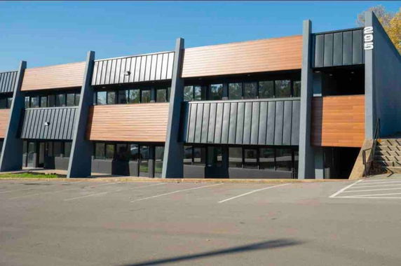 Front view of a modern two-story building with a flat roof and large windows.