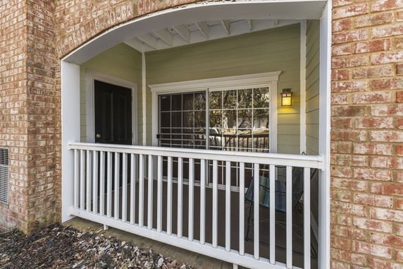 Front view of a house with a small porch area and railing.