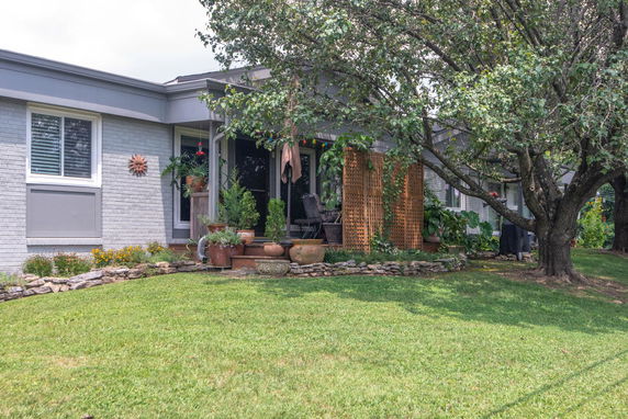 Front view of a single-story house with a patio and garden.