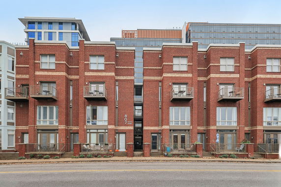 Front view of a multi-story brick building with balconies.