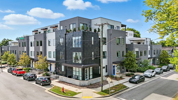 Front view of a modern multi-story building on a street corner.