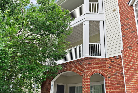 Front view of a multi-story building with brick exterior and balconies.
