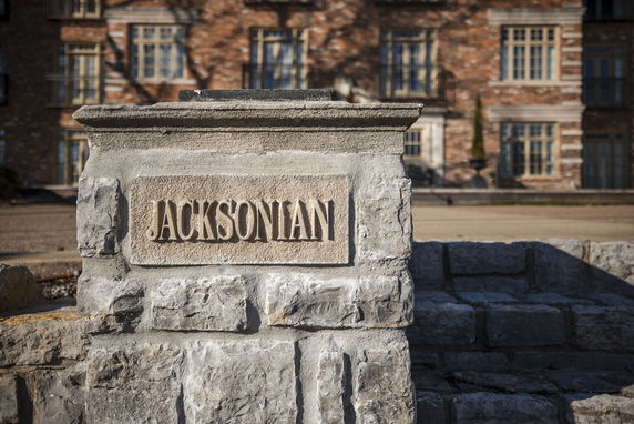 Front view of a building with a nameplate inscribed 'JACKSONIAN' on a stone pillar.