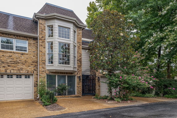 Front view of a house with a brick exterior and a large bay window.