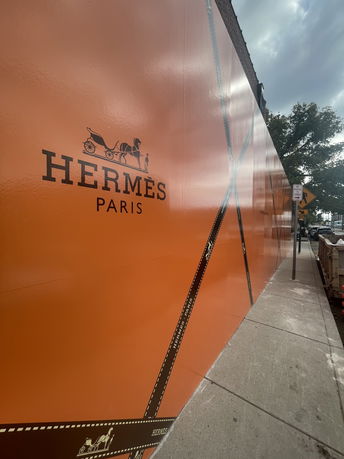 Side view of a building with Hermès Paris branding on an orange wall.