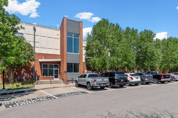Front view of a building with a parking lot in front.