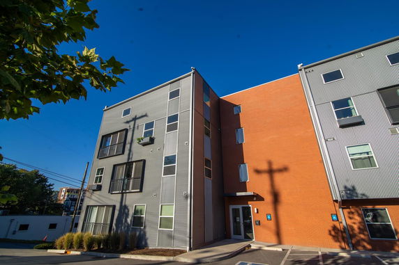 Front view of a modern multi-story building with a combination of brick and metal siding.