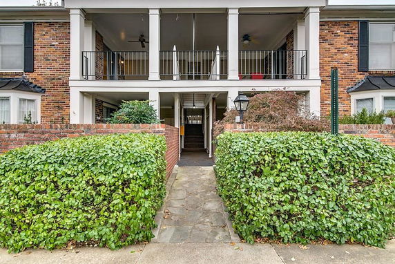 Front view of a two-story brick building with balconies and a central walkway.