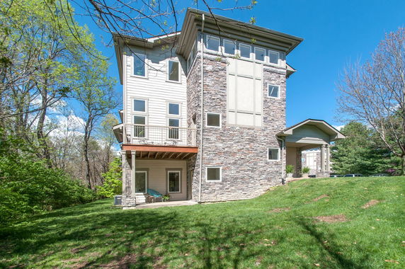 Front view of a multi-story house with stone and siding exterior.
