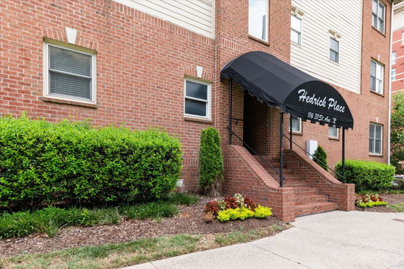 Front view of a multi-story brick building with an entrance canopy.
