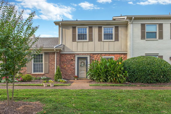 Front view of a two-story townhouse with brick and stone facade.