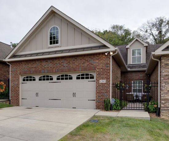 Front view of a brick house with a double garage and gable roof.