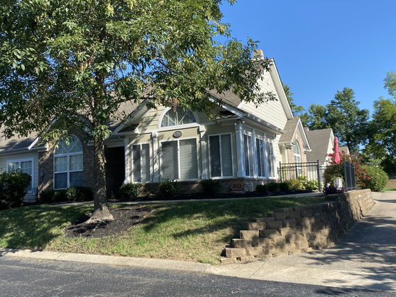 Front view of a single-story house with multiple large windows and a driveway.