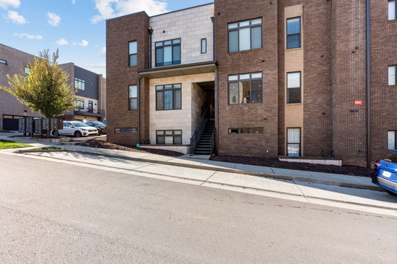 Front view of a modern multi-story brick building with a central entry staircase.