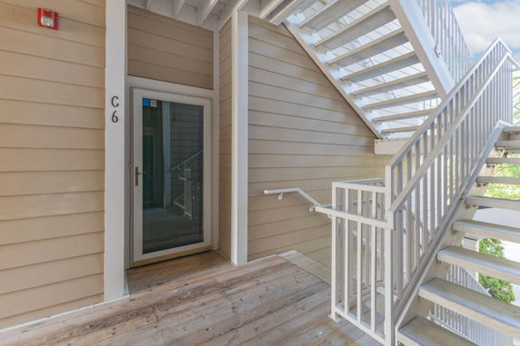 Exterior view of a stairway leading to an apartment entrance.