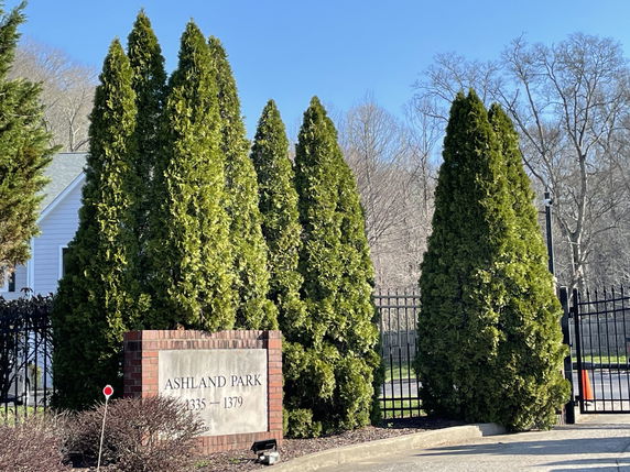 Front view of a house with greenery and a sign reading 'Ashland Park'.