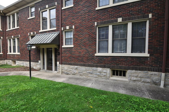 Front view of a brick residential building with multiple windows and an entrance.