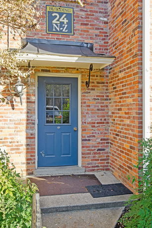 Front view of a building entrance with a blue door and brick exterior.
