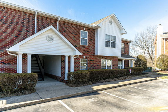 Front view of a two-story apartment building with brick and siding.