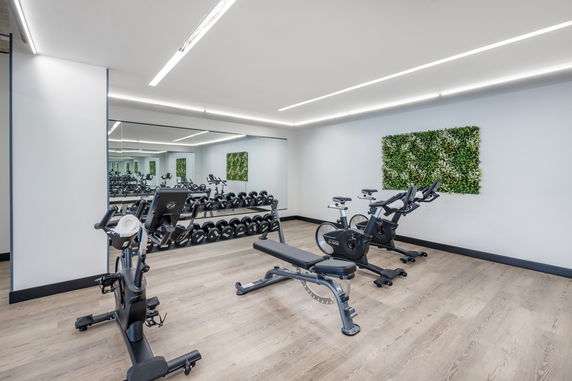 Indoor gym with exercise bikes and dumbbells in a fitness area.