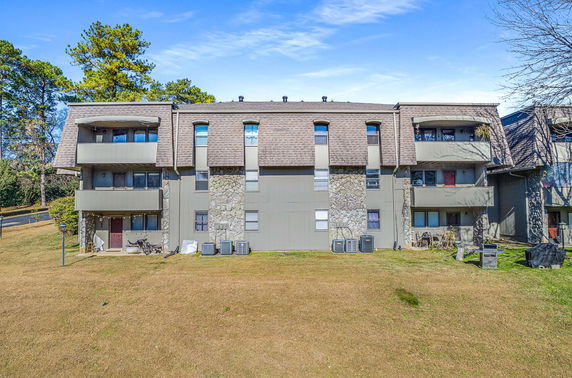 Front view of a three-story apartment building with balconies and stone accents.