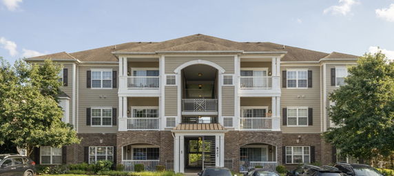 Front view of a multi-story apartment building with balconies.