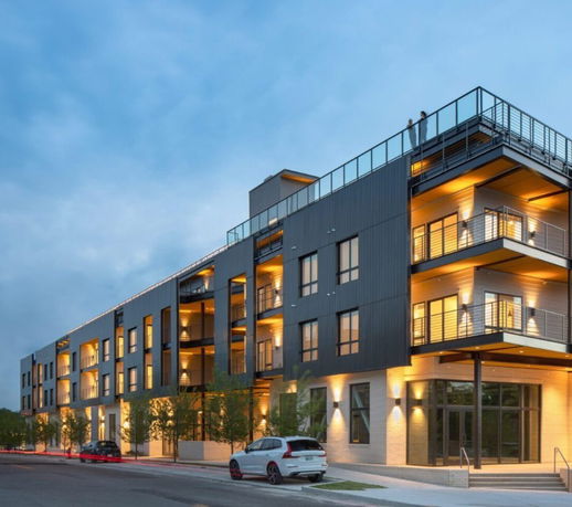 Front view of a modern multi-story apartment building with balconies.