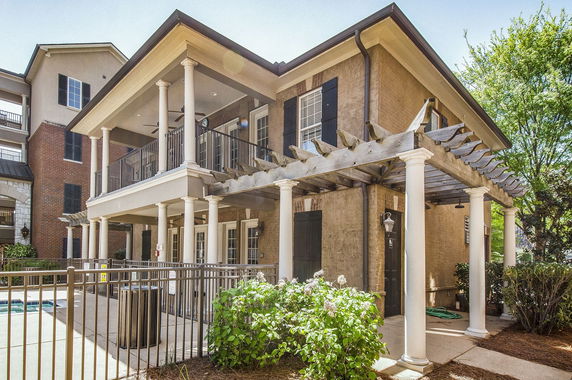 Front view of a two-story house with a covered balcony and columns.