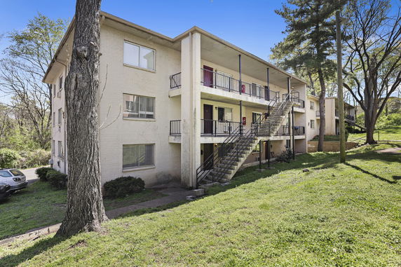 Front view of a three-story apartment building with external staircases.