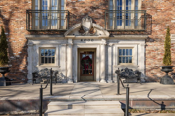 Front view of a brick house with decorative elements and balconies.