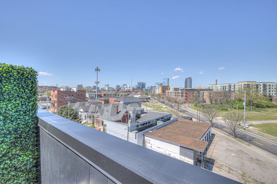 Panoramic view from a rooftop showing a cityscape with buildings and roads.
