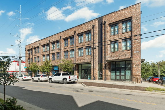Front view of a three-story brick building with large windows and a main entrance.