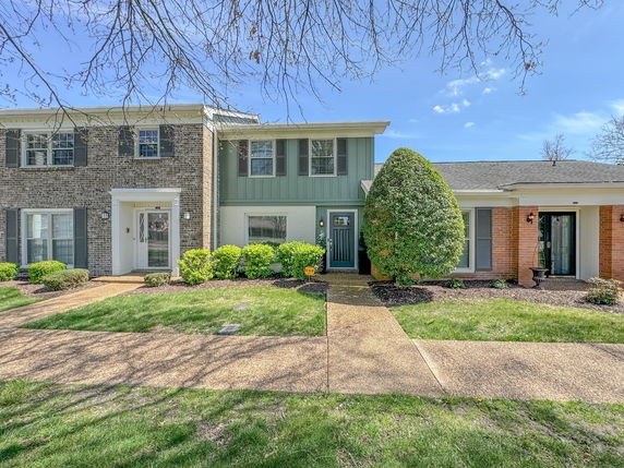 Front view of a two-story brick house with an entrance path.