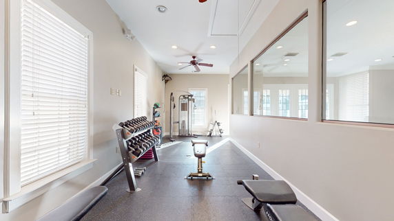 Interior view of a gym with exercise equipment and weights.