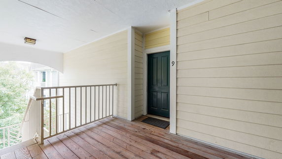 Outdoor walkway leading to a unit entrance with a door labeled number 9.